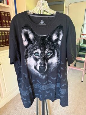 Graphic tee displaying a large wolf head portrait with blue eyes